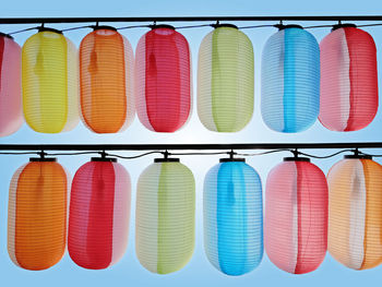 Rows of hanging colorful paper lanterns isolated on blue background