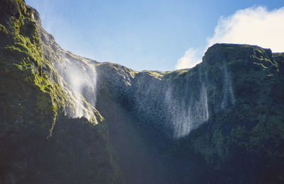 Scenic view of waterfall against sky