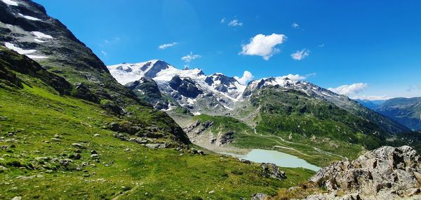 Scenic view of snowcapped mountains against blue sky