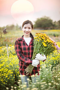 Portrait of smiling young woman standing on field