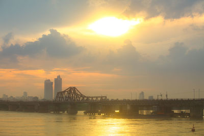 Bridge over river against sky during sunset