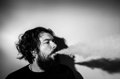 Portrait of man blowing smoke