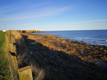 Scenic view of beach against blue sky