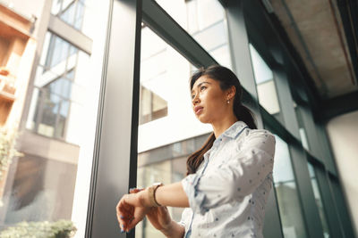 Portrait of young woman standing in bus