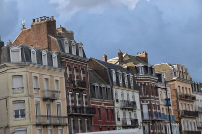 Low angle view of buildings against cloudy sky