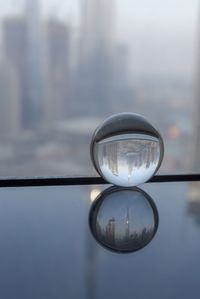 Close-up of crystal ball against sky