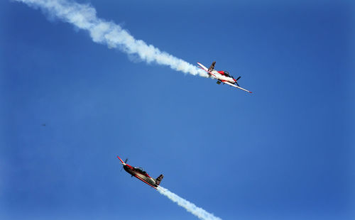 Low angle view of airshow against clear sky