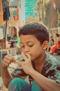 Close-up of teenage boy sitting outdoors