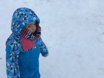 Boy wearing warm clothing on snowy field