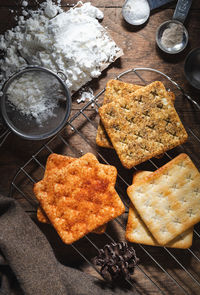 Square dry crackers biscuit on a wooden table. wooden texture dark background. snack dry biscuits