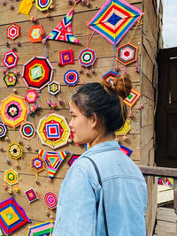 Full length of woman standing against multi colored face