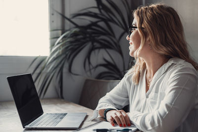 Young woman using laptop at table