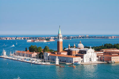 Church of san giorgio maggiore amidst canal against clear blue sky on sunny day