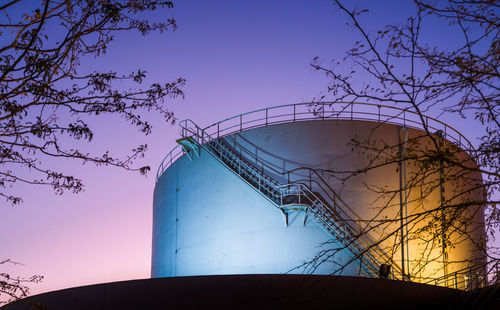 Low angle view of industrial building against dramatic sky during sunset