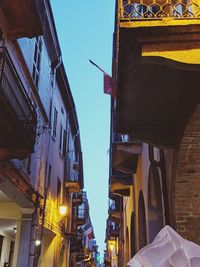 Low angle view of illuminated buildings against blue sky