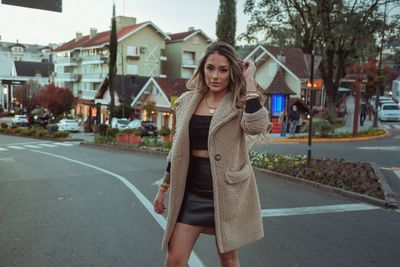 Portrait of woman standing on road in city