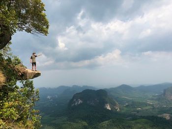 Full length on man standing on cliff against landscape