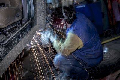 Worker welding in factory