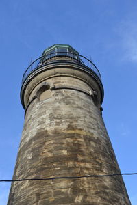 Low angle view of water tower against clear blue sky