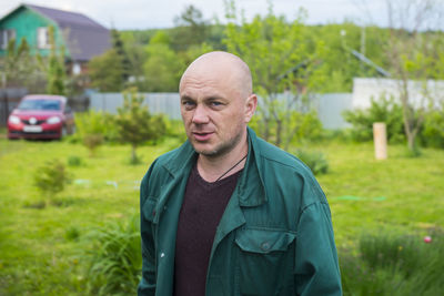 Portrait of young man standing on grassy field