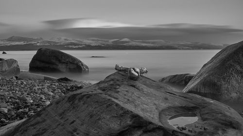 Scenic view of sea and mountains against sky