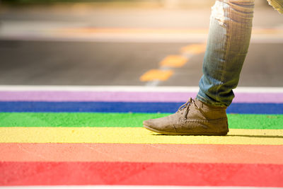 Low section of man walking on colorful street