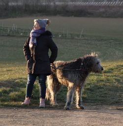 Full length of man with dog standing on field
