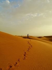 Scenic view of sand dunes in desert against sky