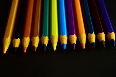 Close-up of multi colored pencils against black background