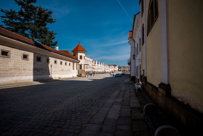 Street amidst buildings in town against sky