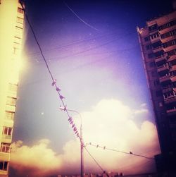 Low angle view of illuminated building against cloudy sky