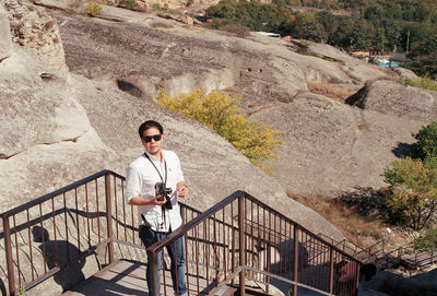 Portrait of young man standing on staircase