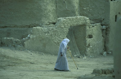 Rear view of woman standing against wall