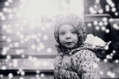 Portrait of cute girl against illuminated lighting equipment