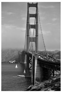 View of suspension bridge against cloudy sky