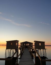 Pier over sea against sky during sunset