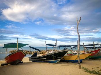 Boats moored on beach against sky