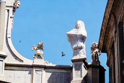 Low angle view of statue against historic building