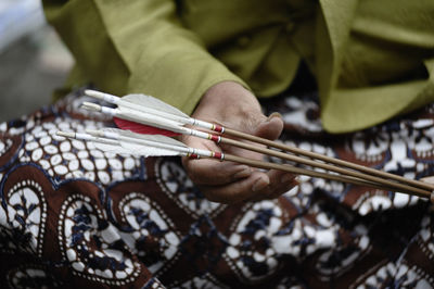 Midsection of man sitting with arrows