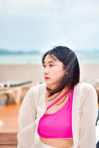 Portrait of young woman standing at beach