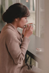 Midsection of man holding coffee while sitting at home