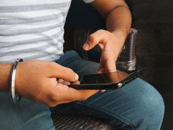 Midsection of man using mobile phone