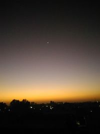 Silhouette city against sky at sunset