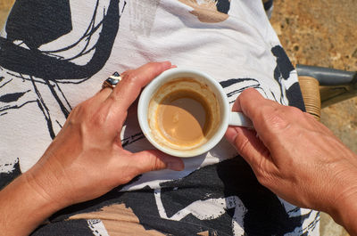 Cup of coffee in woman's hands - shot from above