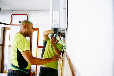 Engineer with colleague using drill machine