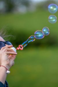 Close-up of young woman blowing bubbles