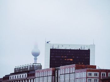 Buildings in city against clear sky