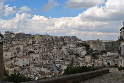 Buildings in city against cloudy sky