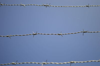 Low angle view of barbed wire fence