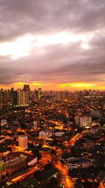 High angle view of illuminated cityscape against sky during sunset